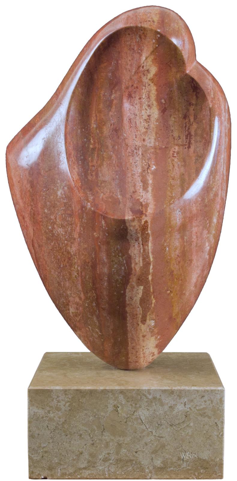 An abstract ovoid carving in reddish stone representing a mother and child.
