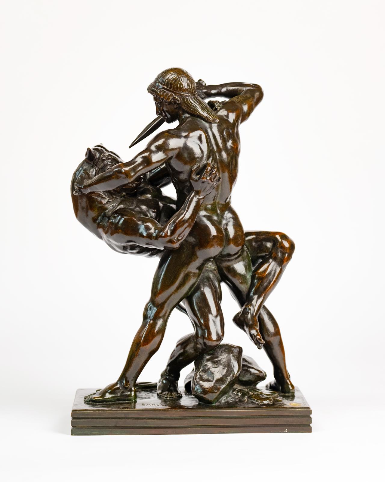 a brown bronze sculpture depicting a struggle between a man and a monotaur