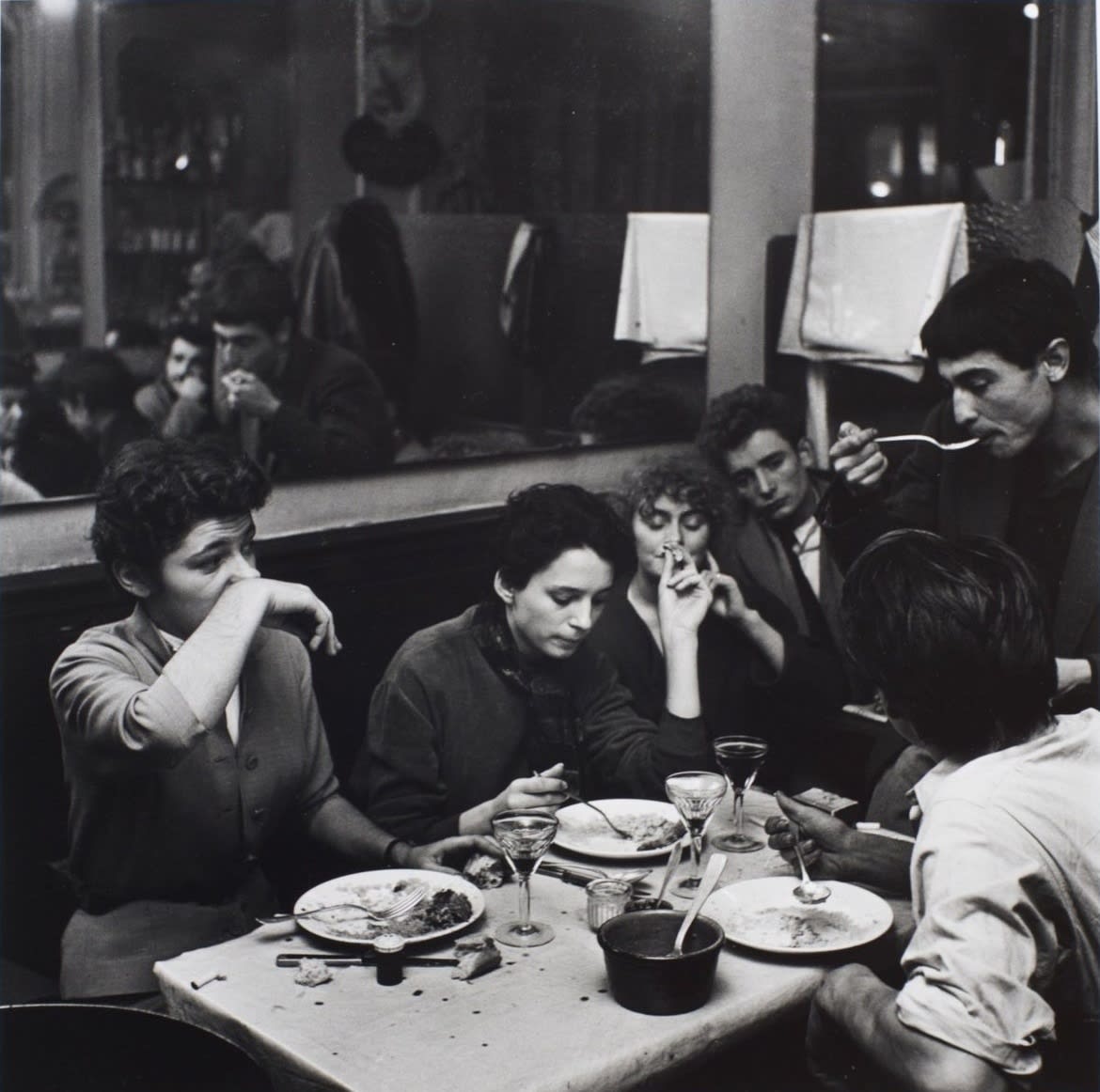 Ed van der Elsken, Dinner in a cafe. Girl wipes her nose with her wrist. Paris, ca. 1952