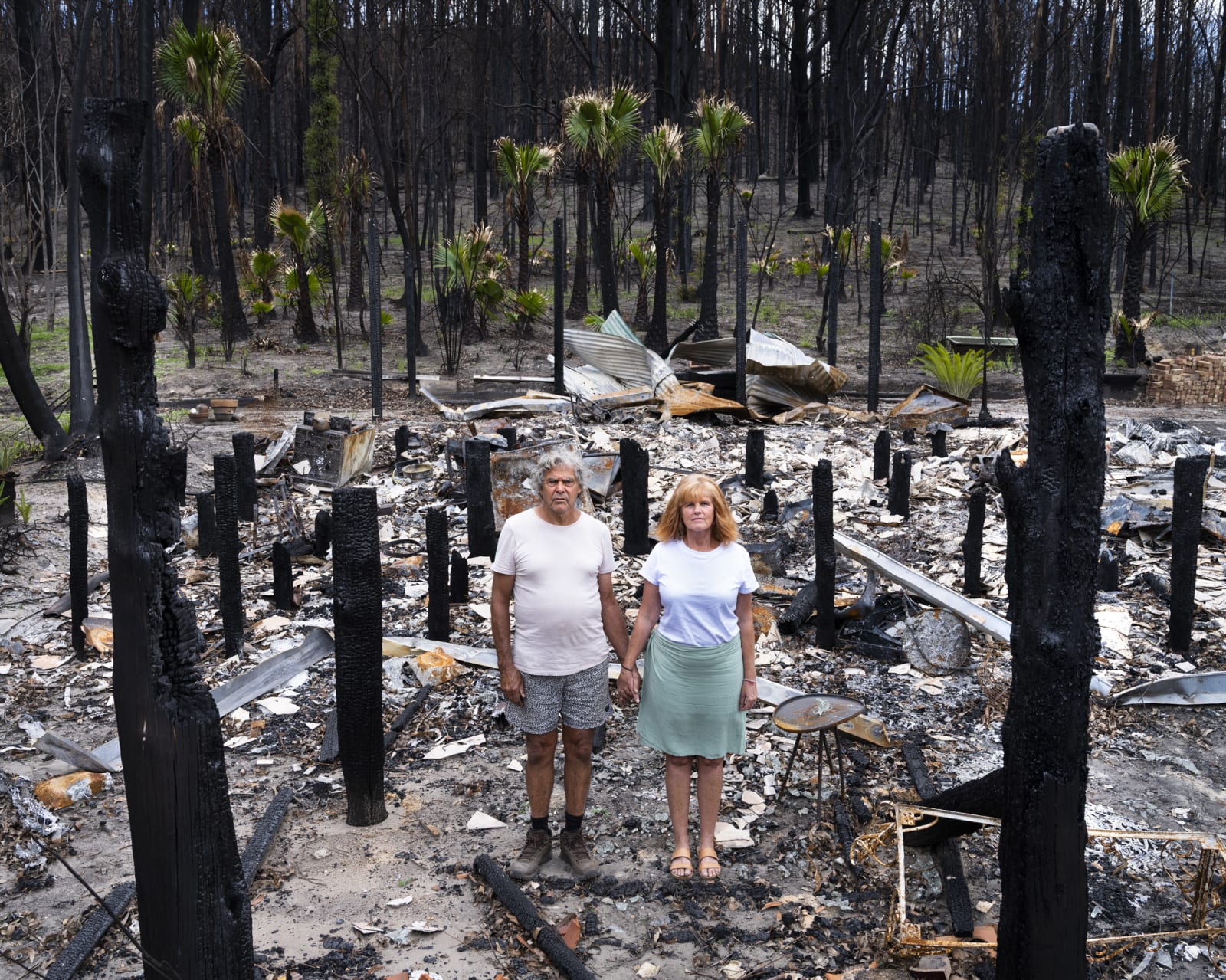 Gideon Mendel, Noel and Trish Butler at their burnt home in Nuragunyu, New South Wales, 2020