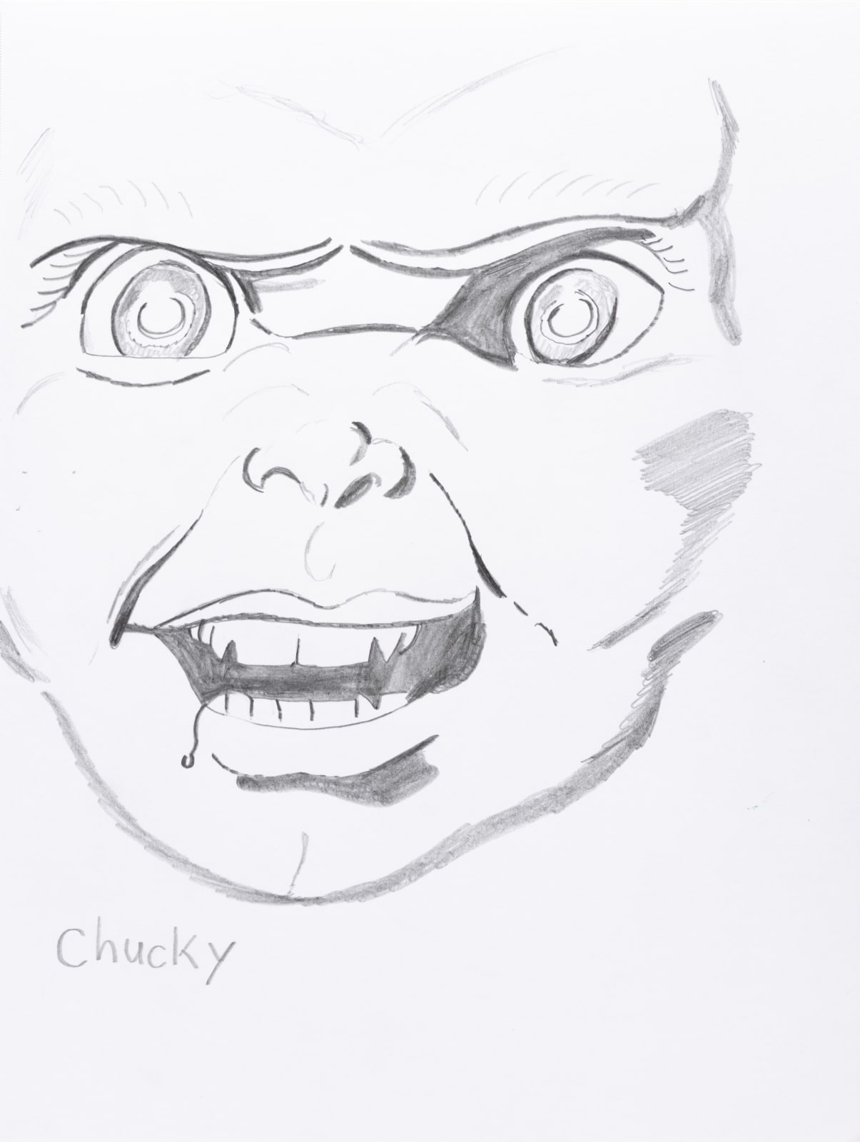 A drawing of a scary face with big eyes and sharp teeth. Text reads 