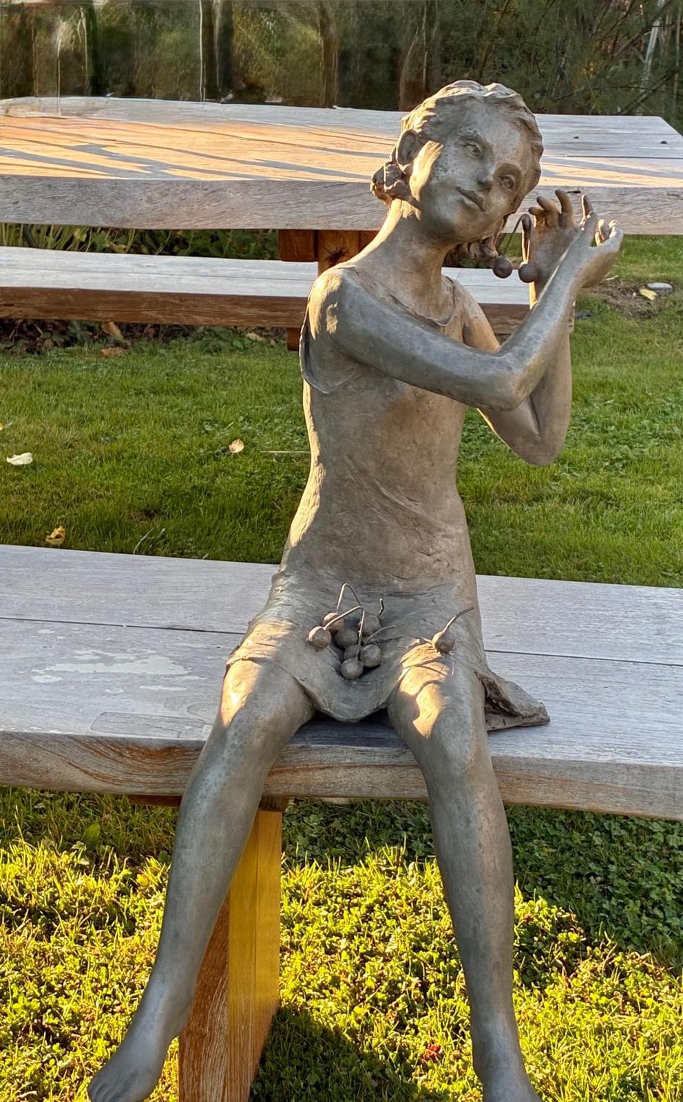 sculpture en bronze, Le Temps des Cerises, Béatrice Cols, artiste belge, enfant en bronze, sculpture figurative, art contemporain, sculpture de jeune fille, patine naturelle, décoration de jardin, art de collection, sculpture extérieure, sculpture pour architectes d’intérieur, œuvre en bronze patiné, sculpture poétique, galerie d’art, bronze belge, sculpture d’enfant