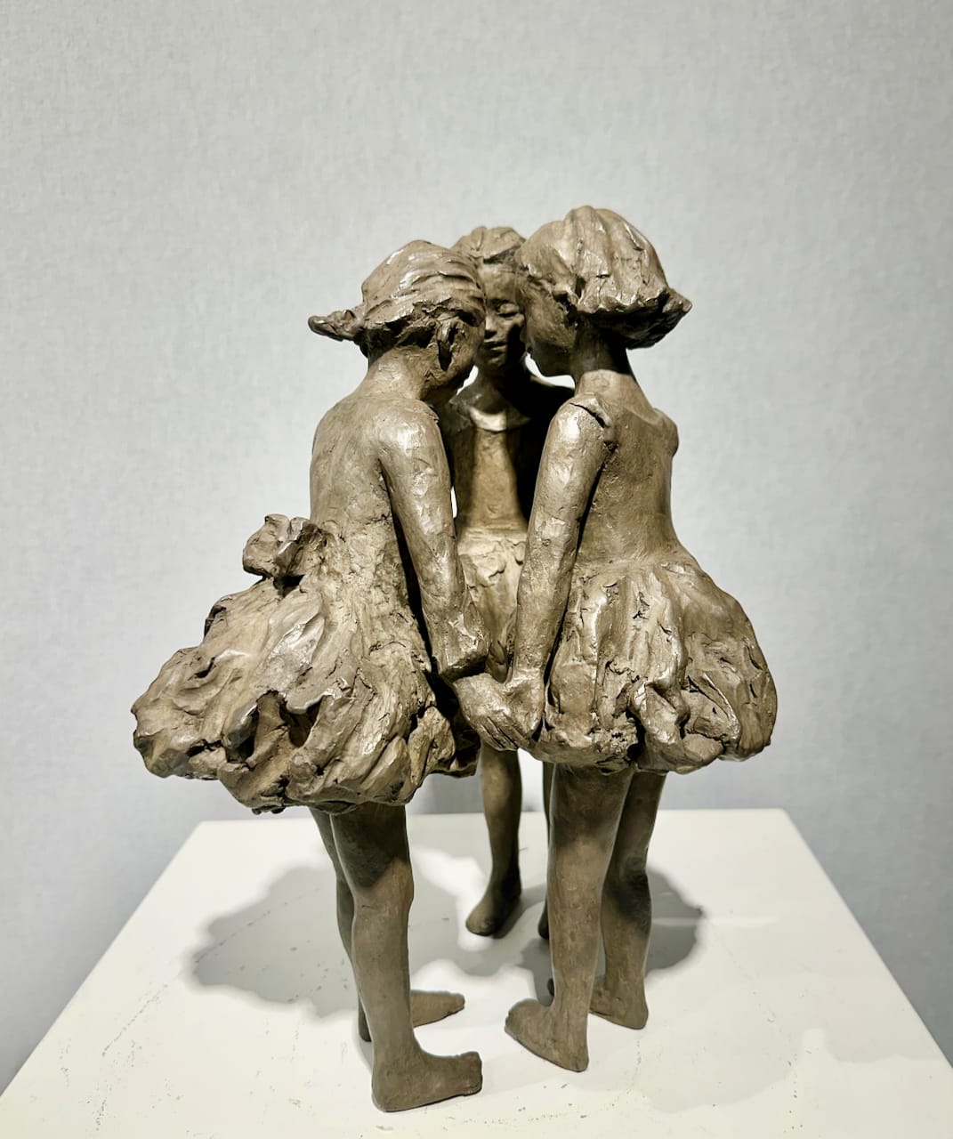 bronzen beeld, De Drie Gratiën, Béatrice Cols, Belgische kunstenares, kinderen in brons, figuratieve sculptuur, meisjes in cirkel, zwierende jurkjes, hedendaagse kunst, poëtisch beeldhouwwerk, interieurdecoratie, tuinbeeld, gepatineerd brons, kunstcollectie, decoratief bronzen beeld