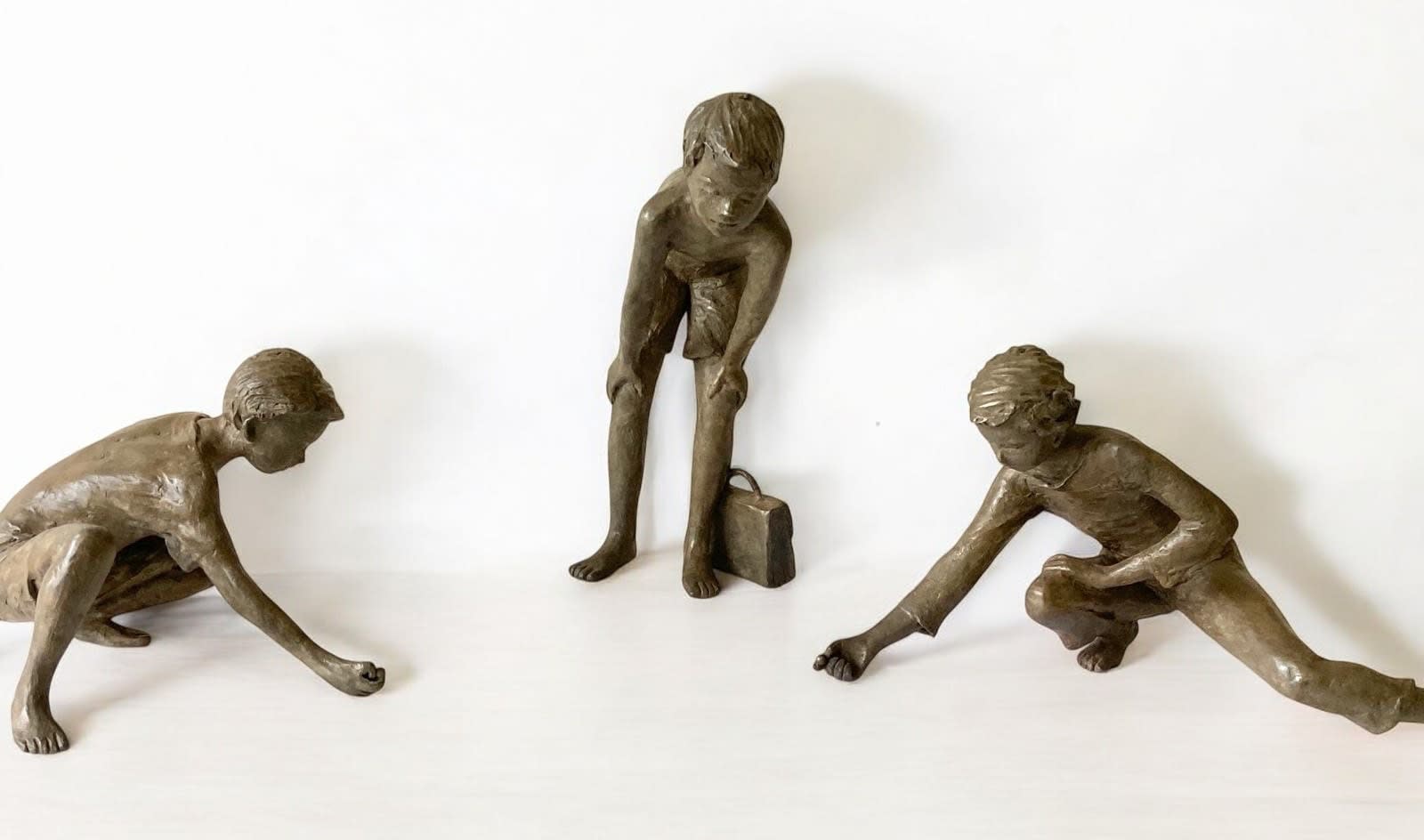Marble players, small figurative bronze sculpture by Béatrice Cols, children playing marbles, poetic and narrative collectible artwork for indoor display