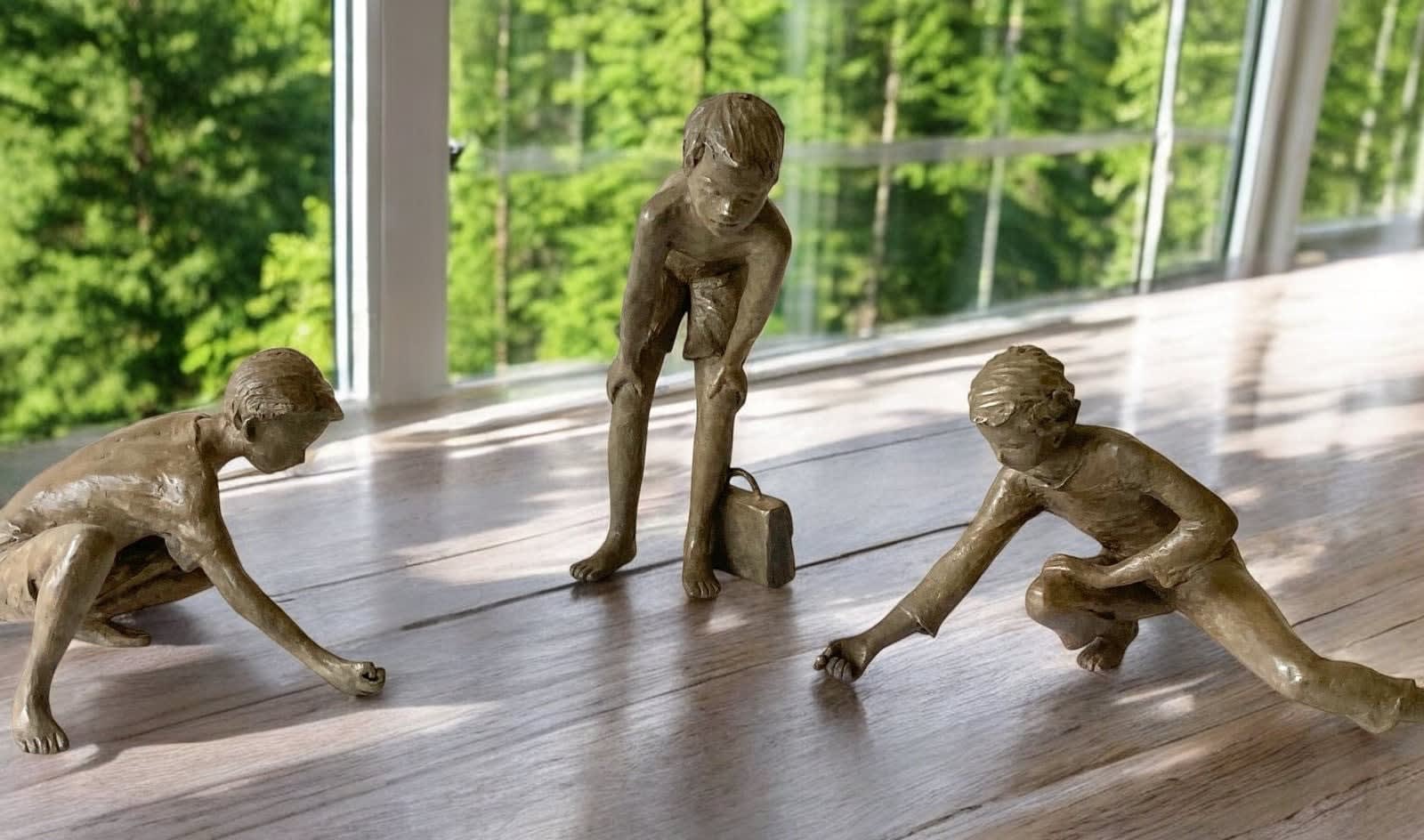 Murmelspieler, kleine figurative Bronzeskulptur von Béatrice Cols, spielende Kinder, poetisches und erzählerisches Sammlerstück für den Innenraum