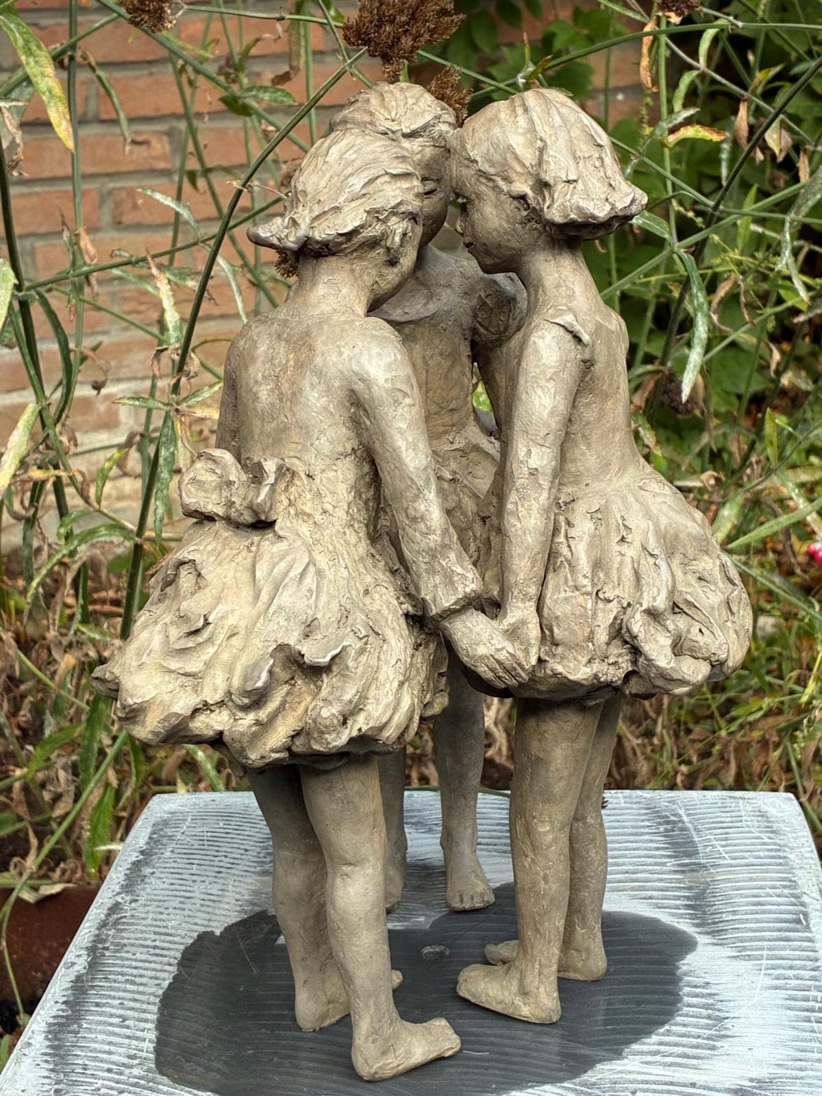 sculpture en bronze, Les Trois Grâces, Béatrice Cols, artiste belge, enfants en bronze, sculpture figurative, fillettes en ronde, robes volantes, art contemporain, sculpture poétique, décoration intérieure, sculpture de jardin, bronze patiné, collection d’art, sculpture décorative