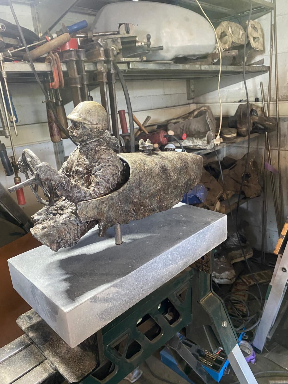 Bronzen beeld “Master of Speed V” van Lieven D’Haese, met een figuur in een gestileerd voertuig en een klein vogeltje op de voorkant.