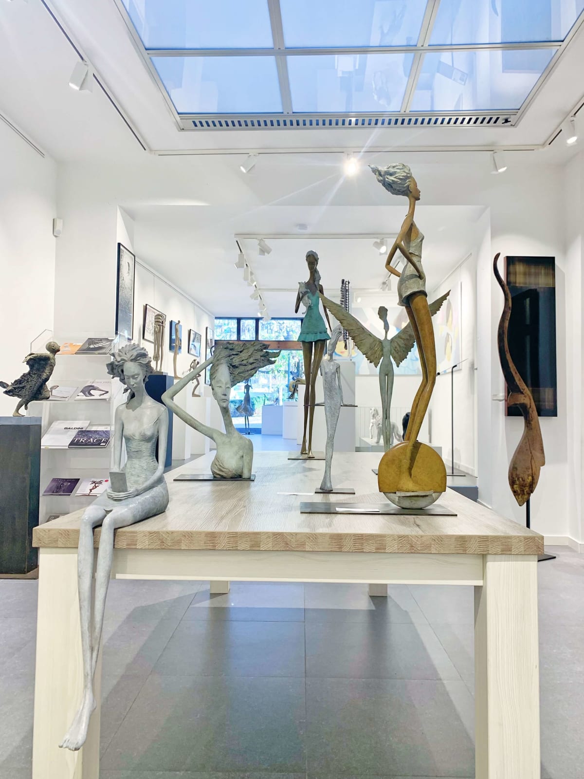 art exhibition hedwige leroux beautiful and fine contemporary city woman bronze sculpture with smart phone and dream art gallery brussels
