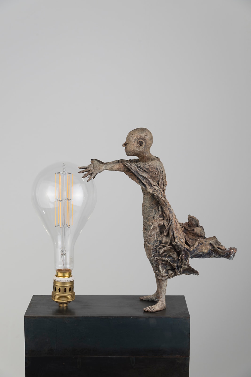 Visionnaire lieven d'haese sculpture contemporaine en bronze d'un garçon allume une ampoule avec son imagination et son inspiration une sculpture art du rêve Art Yi galerie d'art à bruxelles