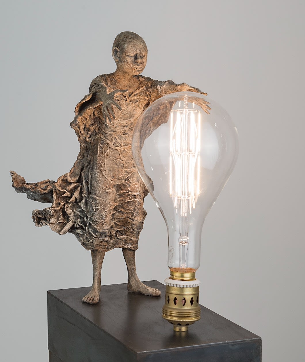 Visionair lieven d'haese hedendaagse bronzen sculptuur van een jongen zet een gloeilamp aan met zijn verbeelding en zijn inspiratie een beeldhouwkunst van droom Art Yi kunstgalerie in brussel