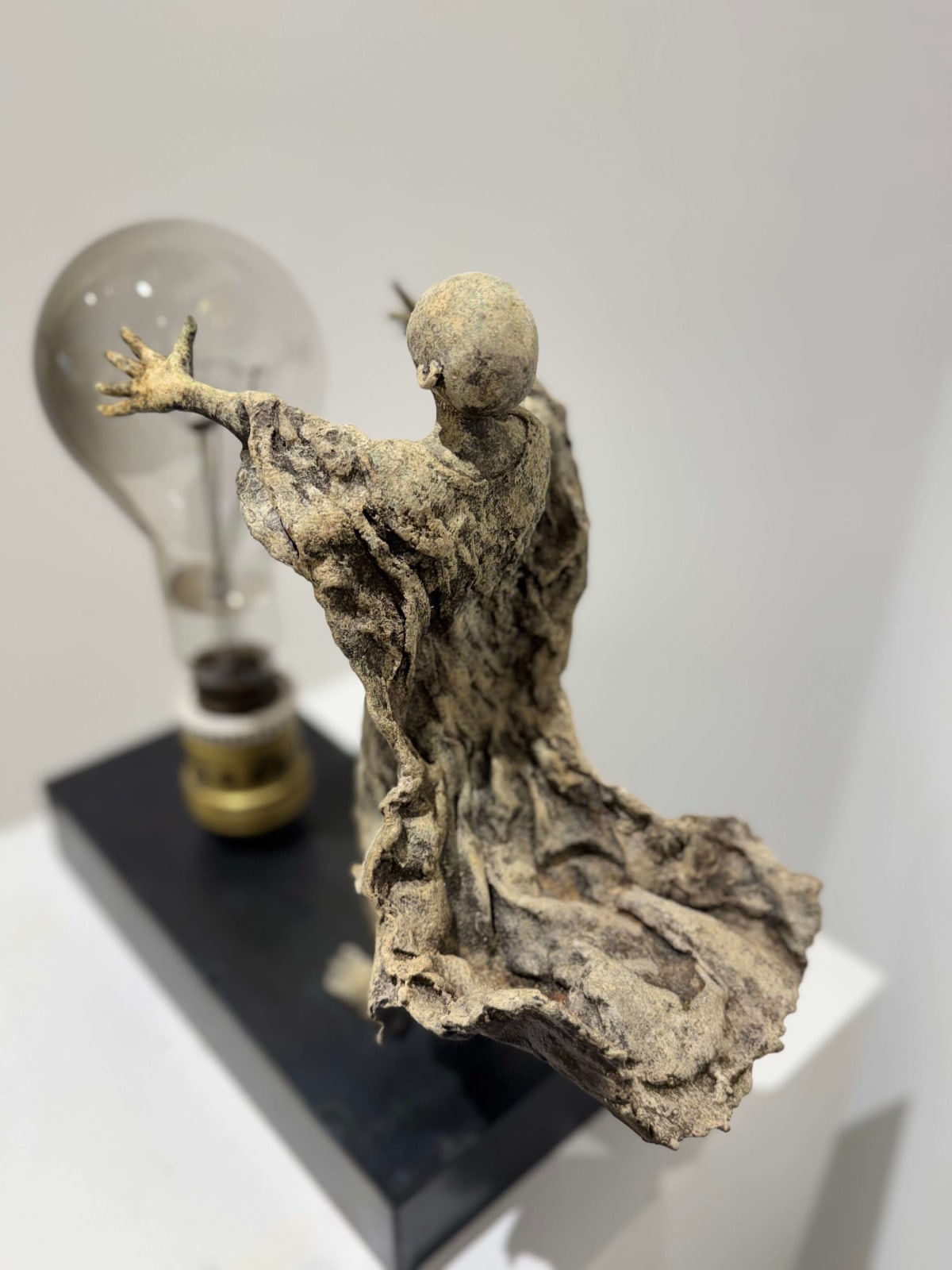 Visionary XL with light boy sculpture bronze sculpture of Lieven d'Haese garden sculpture boy opening arms to light up a light bulb in his hands with imagination magic dream contemporary art sculpture light interior design at Art Yi gallery in Brussels