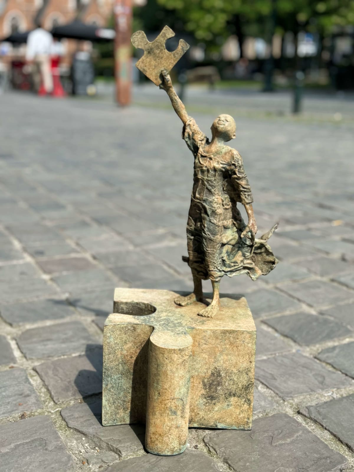 Eureka-Skulptur Lieven D'Haese, träumendes Kind, das ein Puzzle hält und den Stern am Himmel findet, zeitgenössische Skulptur, Bronzeskulptur, figurative Skulptur Art Yi-Galerie Brüssel