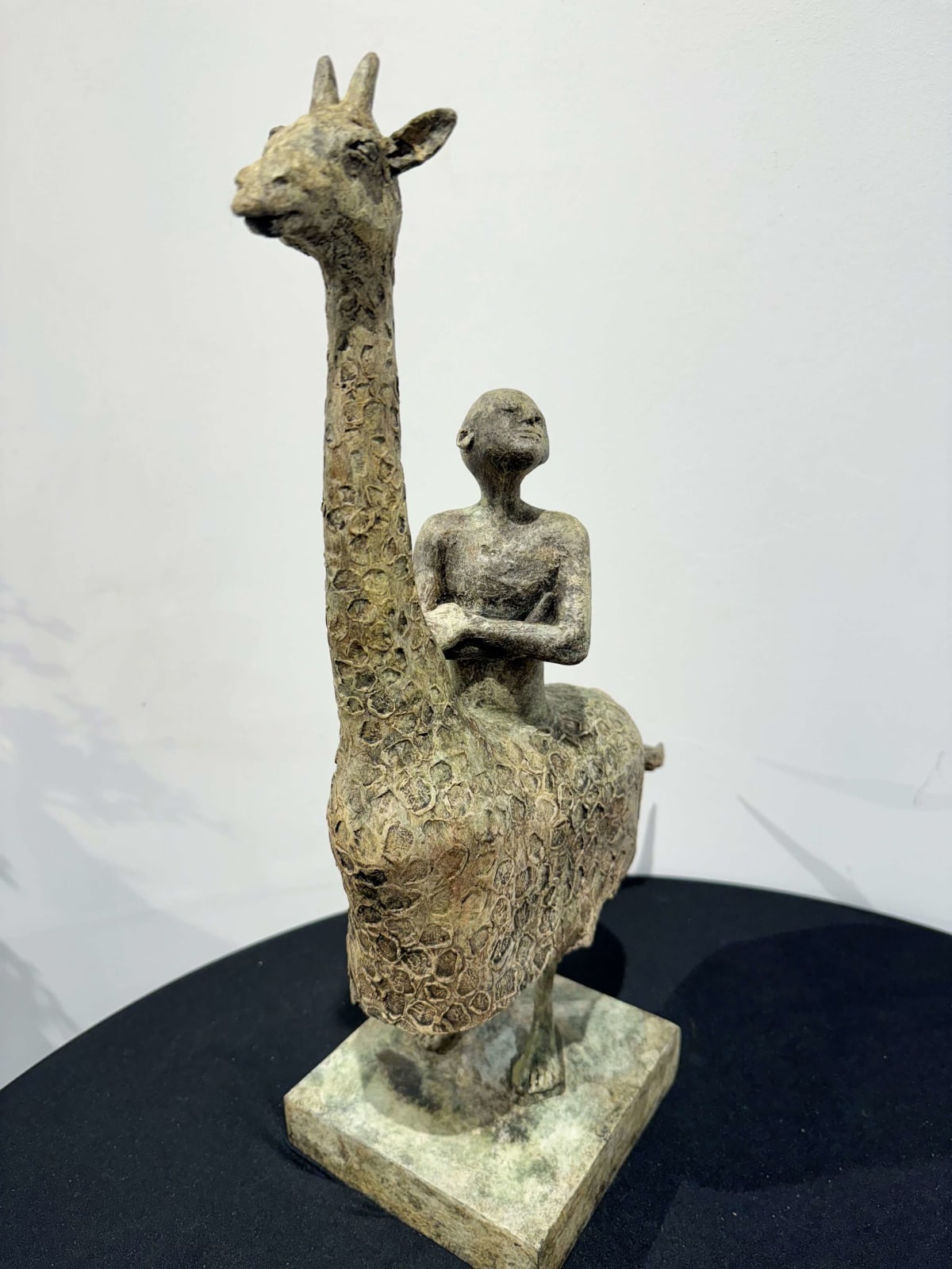 Twee benen giraffe sculptuur lieven D'haese hedendaagse sculptuur bronzen sculptuur van een jongetje dat op een giraffe rijdt dierensculptuur kind sculptuur droom kindertijd Art Yi gallery Brusselse kunstgalerie
