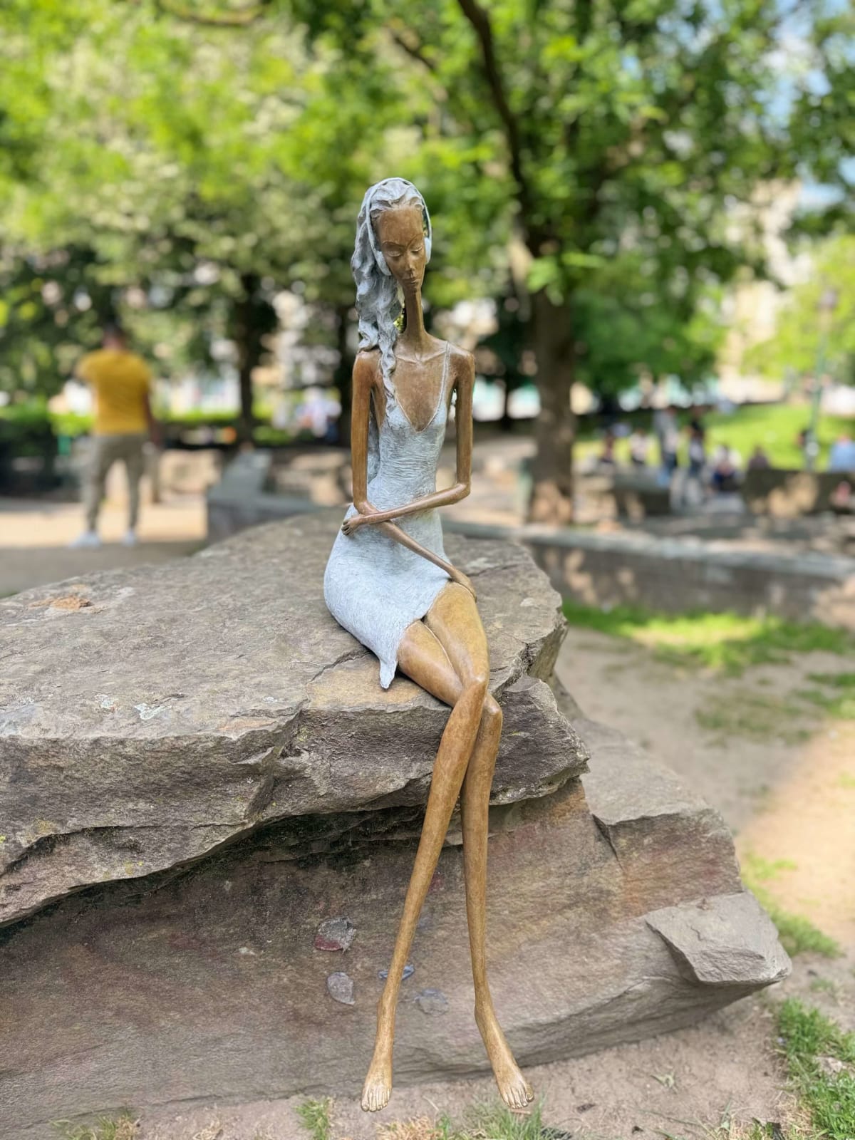 Stand by me vrouw sculptuur Hedwige Leroux hedendaagse kunst hedendaagse sculptuur interieurontwerp een sculptuur van een jong stadsmeisje dat in jeans ligt en naar muziek luistert een meisje dat zit en met haar koptelefoon naar muziek luistert Galerie Art Yi Brussels Art Gallery