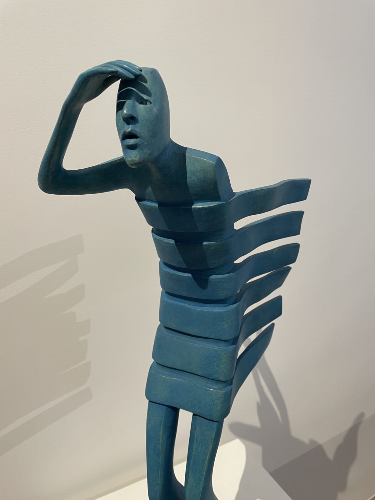Isabel miramontes sculpture contemporaine en bronze art abstrait sculpture décoration design minimalisme horizon une sculpture de figurine bleue regardant loin au bord de la mer contre le vent