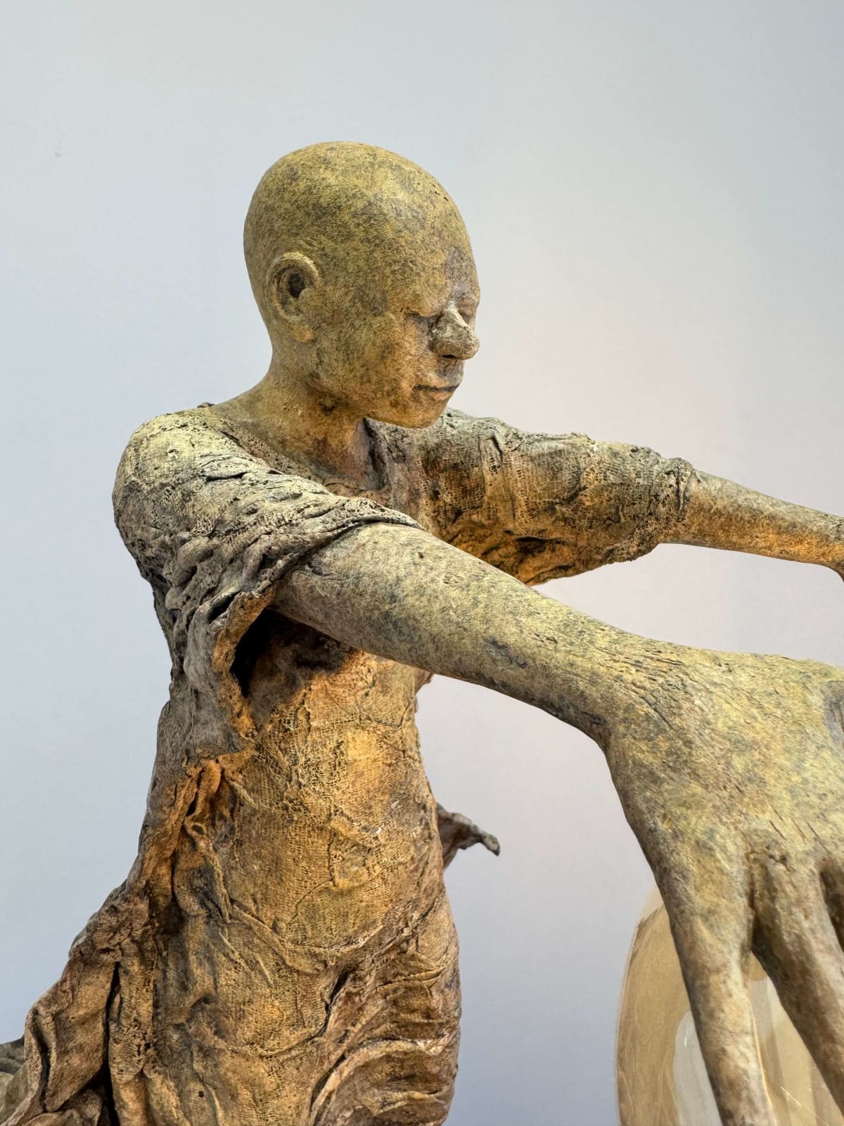 Visionary XL, sculpture lumineuse en bronze de Lieven d'Haese représentant un garçon ouvrant les bras pour allumer une ampoule, symbole d'imagination, de magie et de rêve. Sculpture d'art contemporain, design lumineux et design d'intérieur, exposée à la galerie Art Yi à Bruxelles.