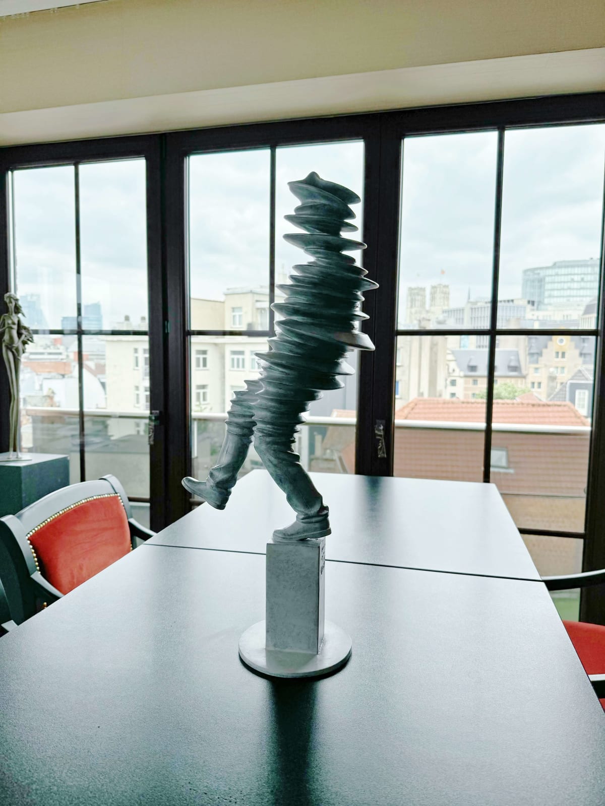 Walkman contemporary sculpture Liang Binbin a light grey bronze sculpture of a man walking and jumping in the rain with shadow figurative sculpture Art Yi gallery Brussels art gallery