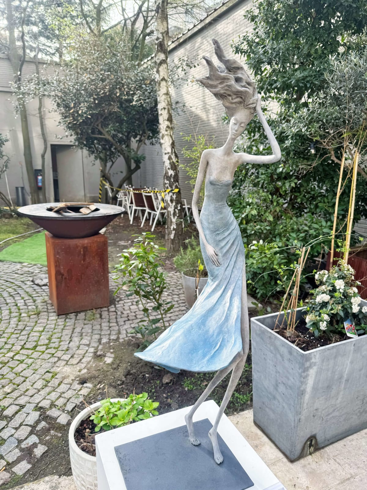 Vom Winde verweht Frauenskulptur Hedwige Leroux zeitgenössische Skulptur Gartenskulptur Bronzeskulptur Frau mit in den Wind wehenden Haaren Innenarchitektur im Hotel Barsey von Warwick Art Yi Galerie Brüsseler Kunstgalerie