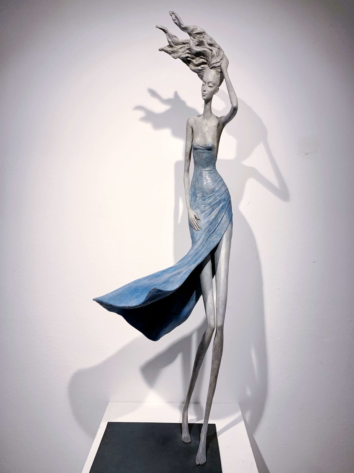 hedwige leroux, gone with wind, contemporary woman sculpture, a beautiful young girl walking in the wind with her blue dress fly to the sky Art Yi gallery Brussels art yi gallery