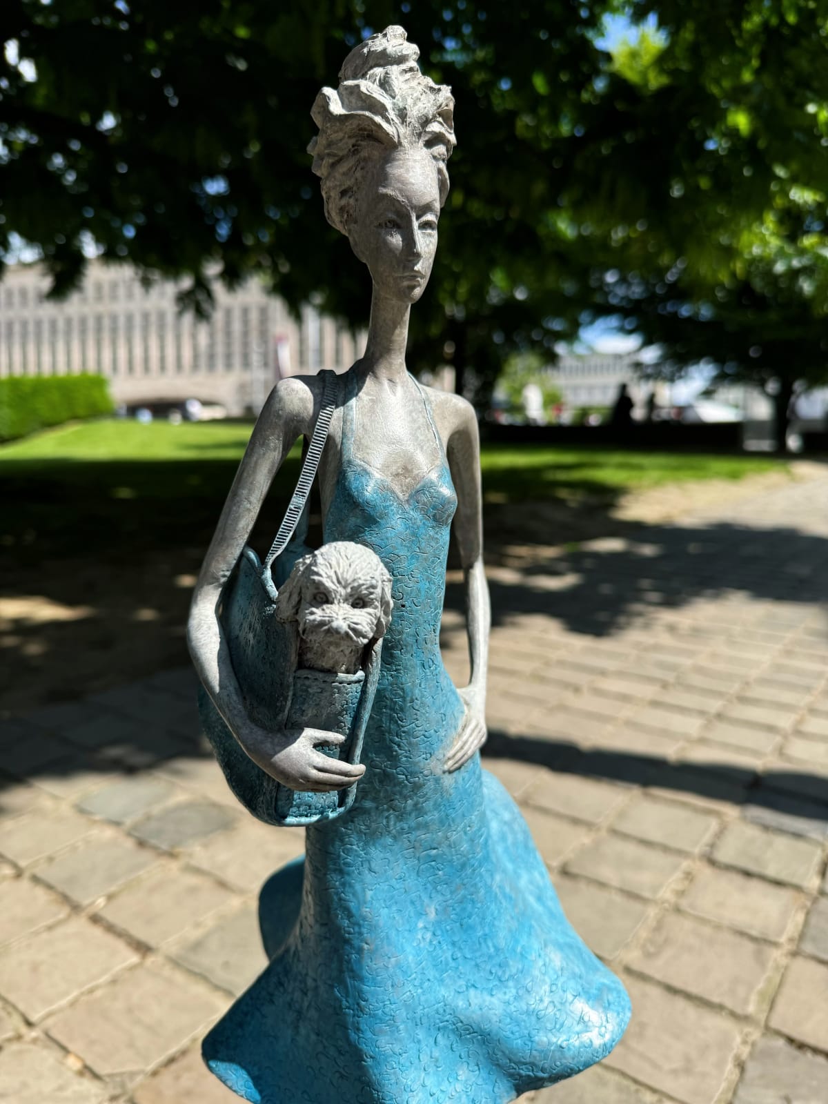 Fifth avenue contemporary woman sculpture Hedwige Leroux a young girl under a blue dress blowing in the wind while carry a little dog in her bag bronze sculpture Art Yi gallery Brussels art gallery
