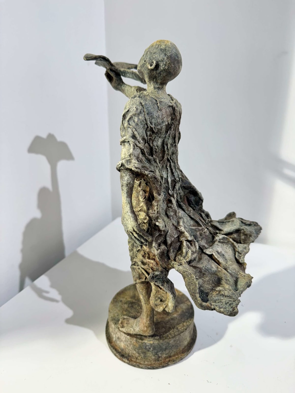 Le garçon pilote sculpture lieven D'haese sculpture contemporaine sculpture en bronze d'un petit garçon qui essaie de lancer un vol en papier dans le ciel sculpture d'enfant rêve d'enfance Galerie d'art Yi Galerie d'art de Bruxelles