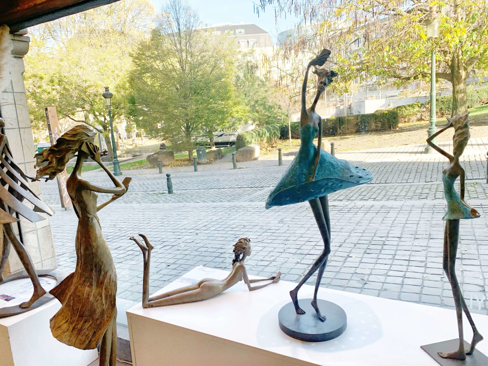 exposition d'art hedwige leroux belle et belle femme de ville contemporaine sculpture en bronze avec téléphone intelligent et rêve galerie d'art bruxelles sculpture au jardin