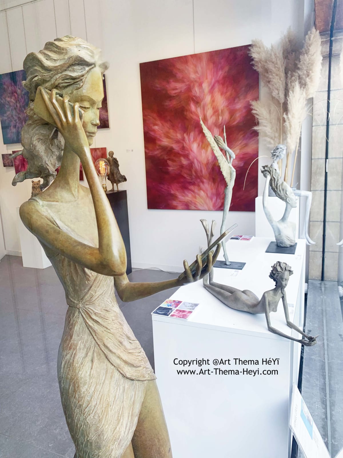 achter de schermen hedwige leroux hedendaagse beeldhouwkunst tuinbeeldhouwwerk mooi en fijn geklede vrouwen bronzen beeld kijkend naar haar smartphone kunst yi art gallery brussel