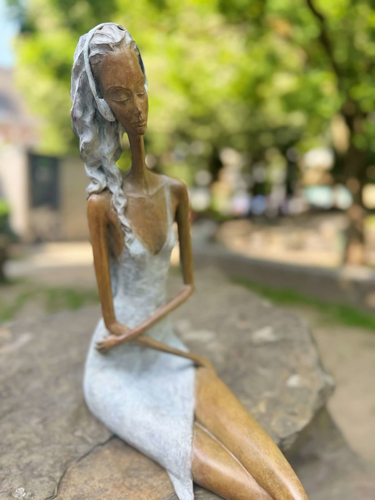 Stand by me sculpture de femme contemporaine Hedwige Leroux art contemporain sculpture contemporaine design d'intérieur une sculpture d'une jeune citadine allongée en jean et écoutant de la musique une fille assise écoutant de la musique avec ses écouteurs Galerie Art Yi Galerie d'art de Bruxelles