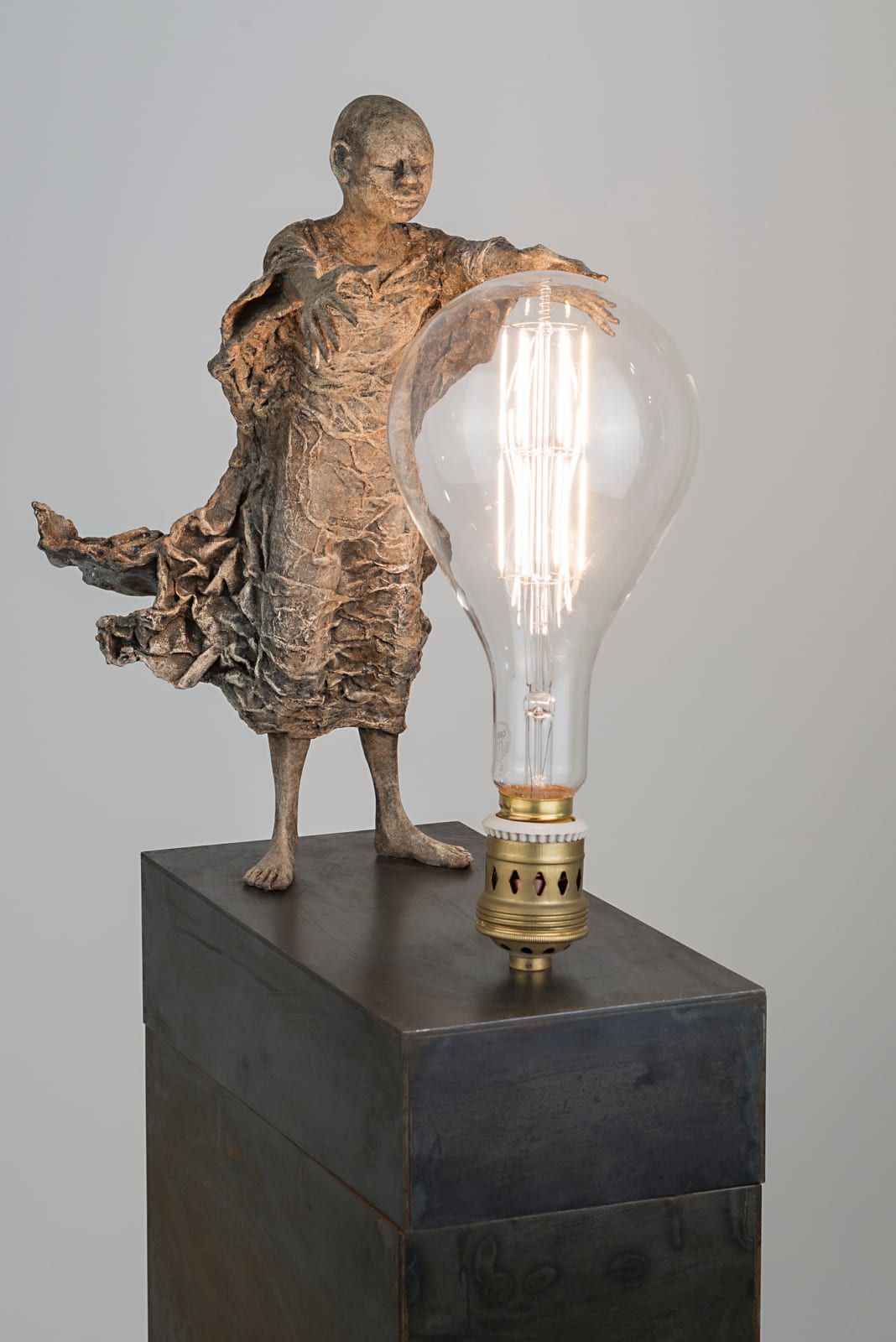 Visionary lieven d'haese contemporary bronze sculpture of a boy turn a light bulb on with his imagination and his inspiration a sculpture art of dream Art Yi art gallery in brussels