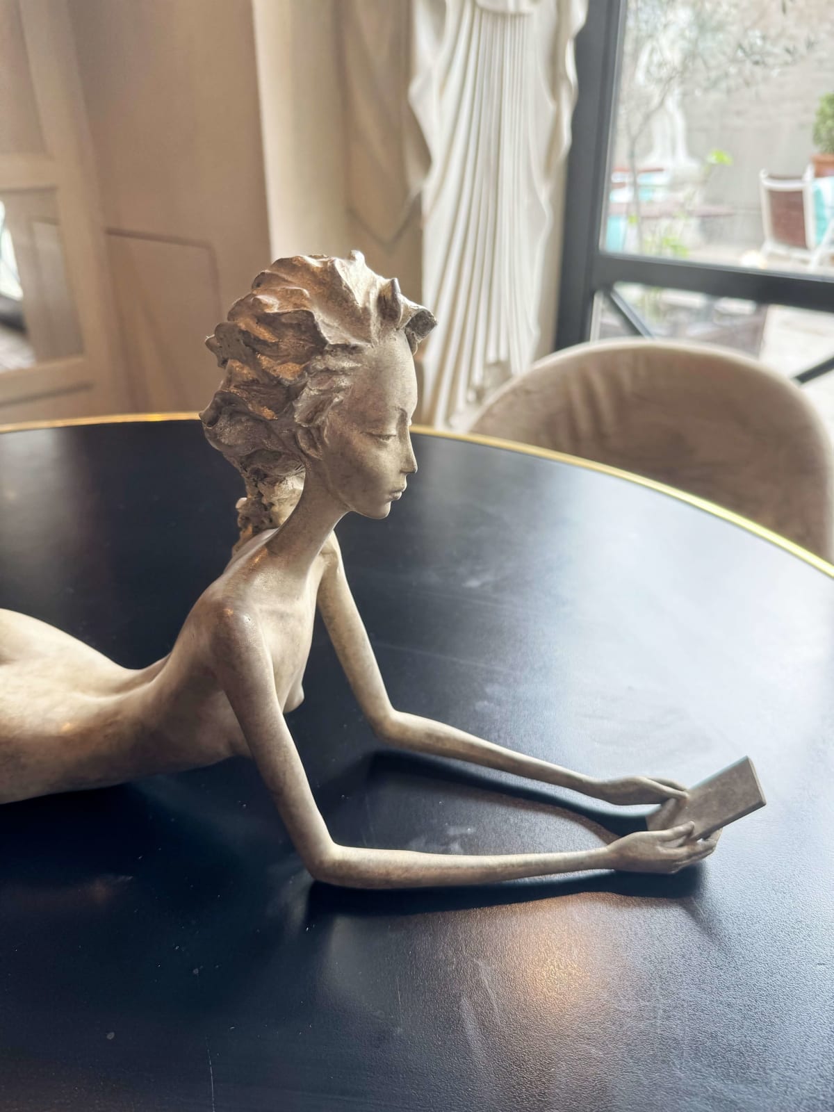 Ich vermisse dich, Hedwige Leroux, eine wunderschöne und feine Bronzeskulptur einer zeitgenössischen Frau, die sich hinlegt und ihr Smartphone betrachtet. Innenarchitektur, zeitgenössische Skulptur im Hotel Barsey von Warwick in Brüssel Art Yi-Galerie Brüsseler Kunstgalerie