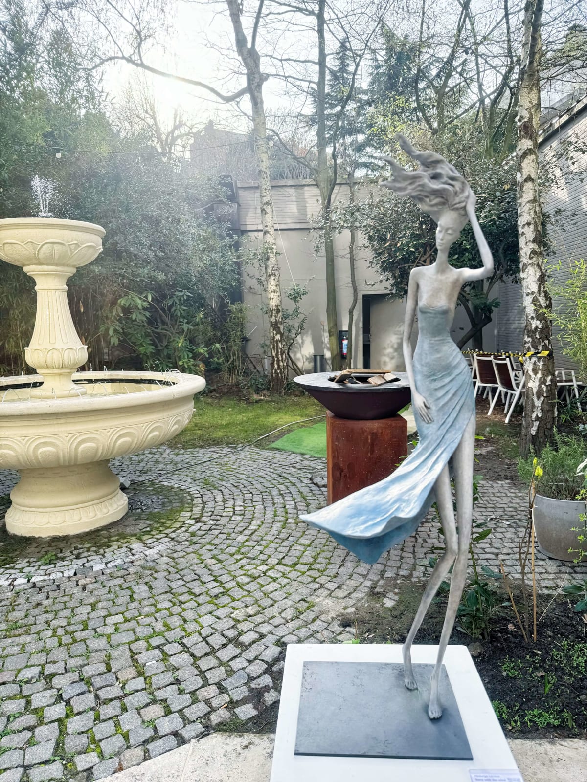 Vom Winde verweht Frauenskulptur Hedwige Leroux zeitgenössische Skulptur Gartenskulptur Bronzeskulptur Frau mit in den Wind wehenden Haaren Innenarchitektur im Hotel Barsey von Warwick Art Yi Galerie Brüsseler Kunstgalerie