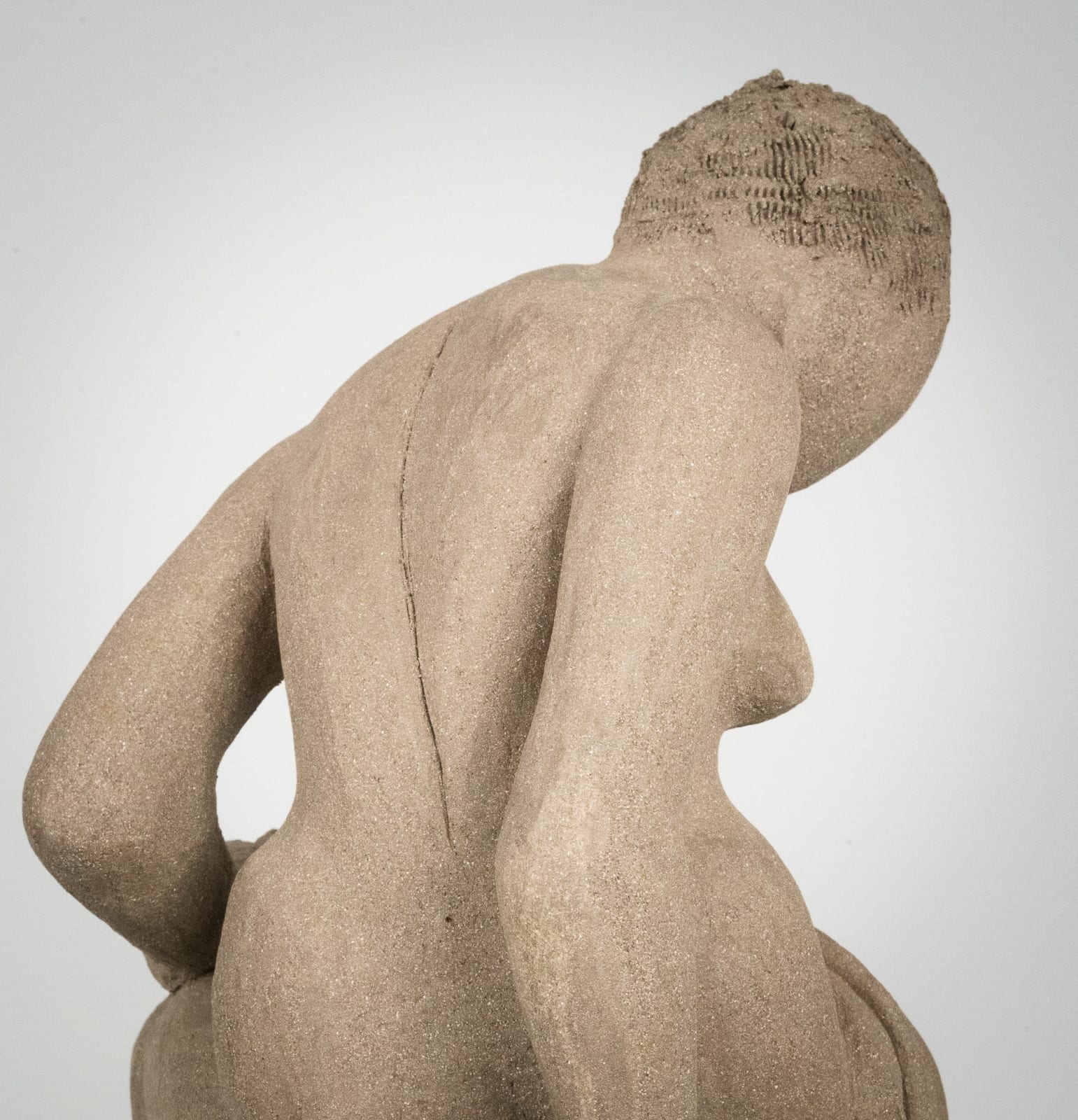 Figurative ceramics sculpture by artist Emilio DiIorio. Female figure is No. 4 in artist's Seated Bathers series in gray clay.