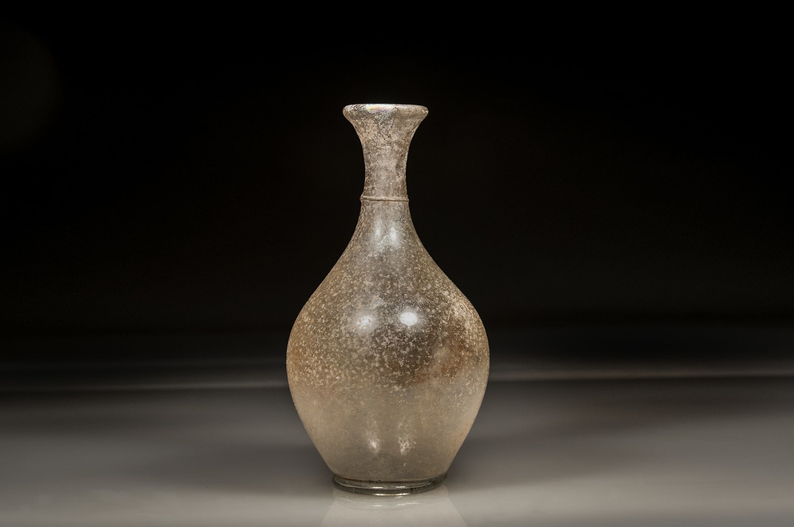 An Elegant Translucent Roman Glass Bottle, Circa 100 C.E. - 300 C.E.