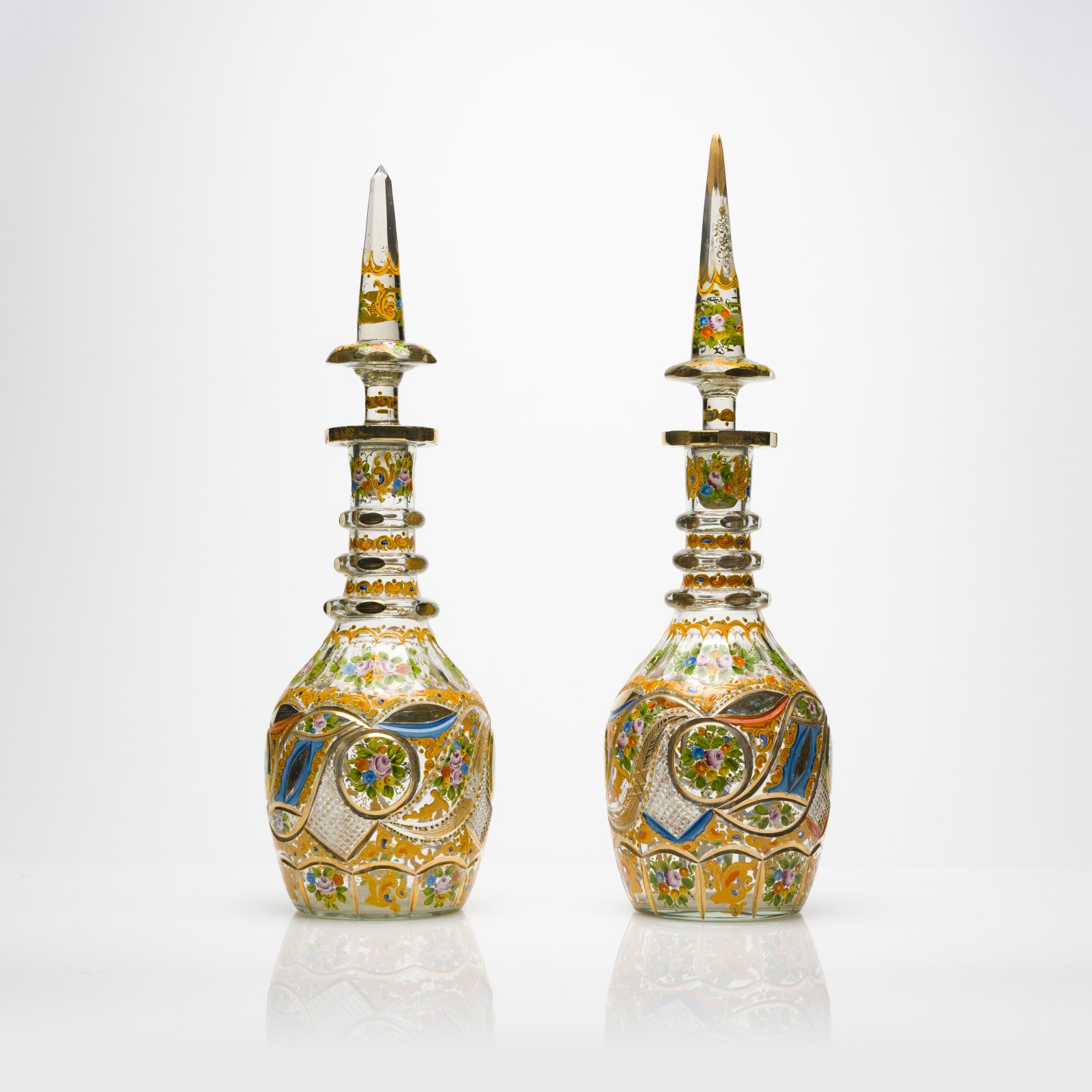 Qajar period pair of glass decanters with painted floral decoration, 19th Century CE