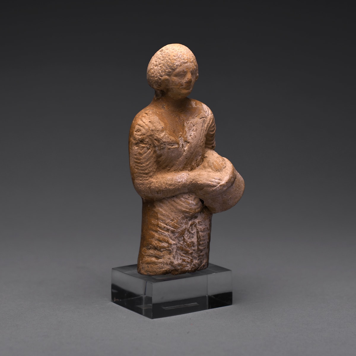 A Hellenistic Terracotta Statue of a Drummer, 4th Century BC