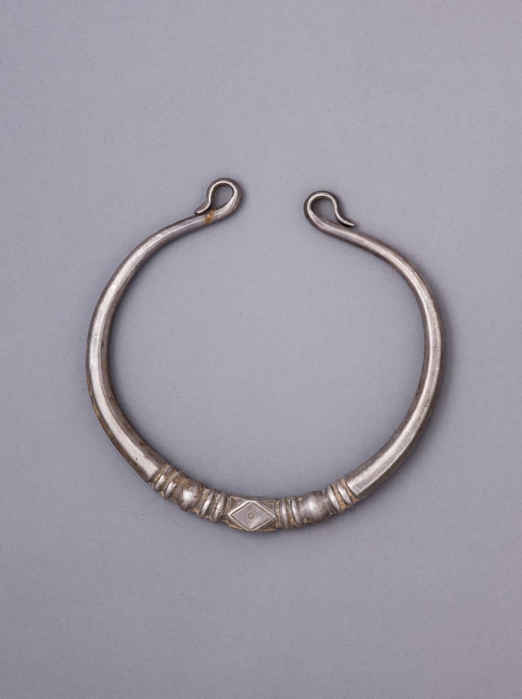 Silver torque decorated by abstract and linear engraving