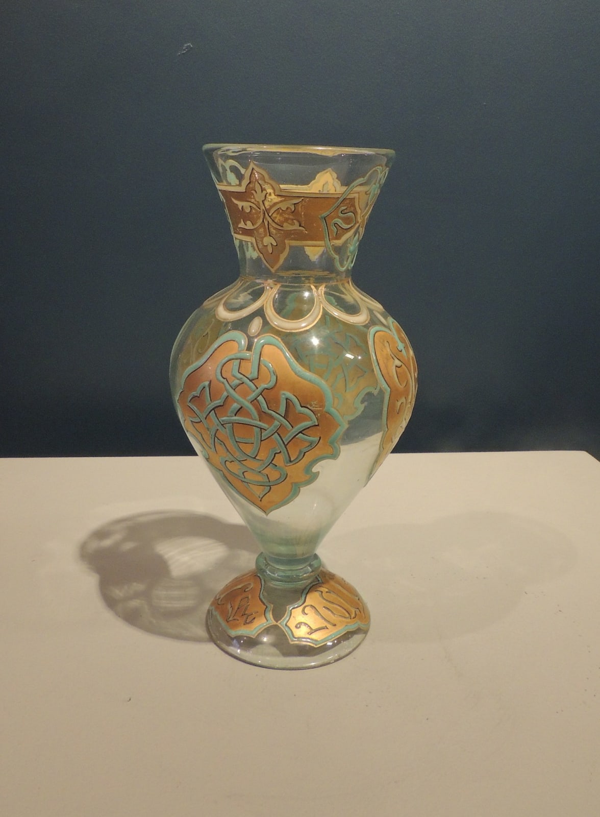 Small baluster shaped vase in clear glass with arabesque decorations in azure on a gold background