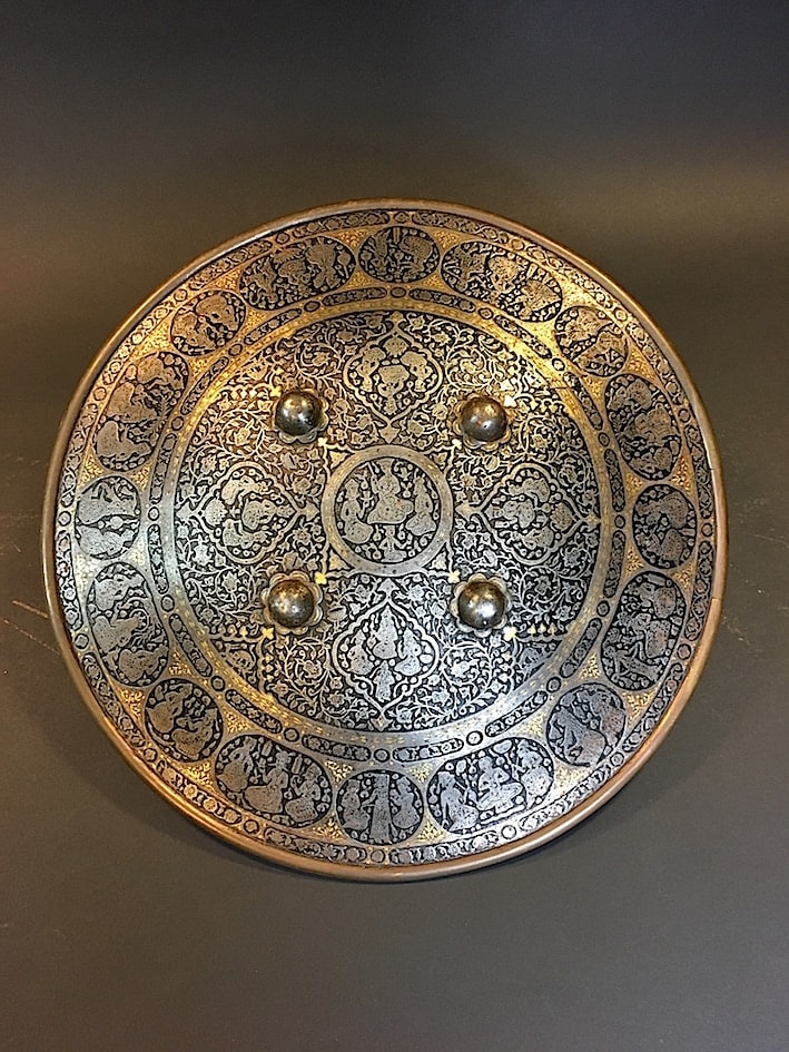 Steel round parade-shield richly engraved with figural scenes and decorated by four bosses, 1795 CE - 1925 CE
