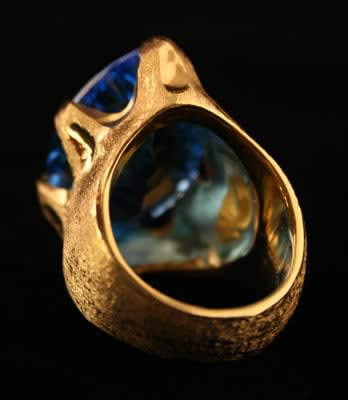 18 Karat Gold Ring with a Florentine Finish Featuring a Blue Topaz