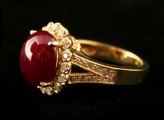 18 Karat Gold Ring Featuring a Cabochon Ruby with 50 Diamonds