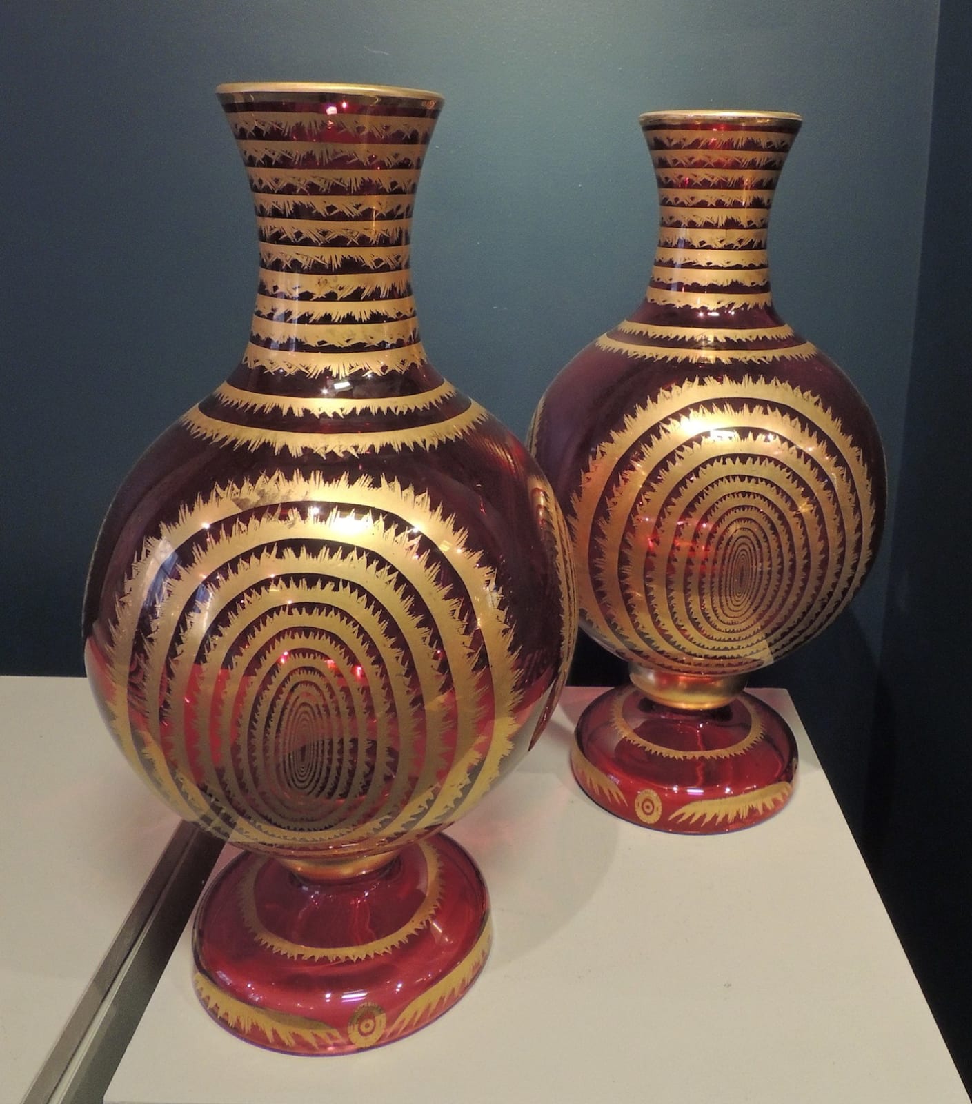 Pair of hand-blown and decorated cranberry glass hookah-base shaped vases, 19 BCE