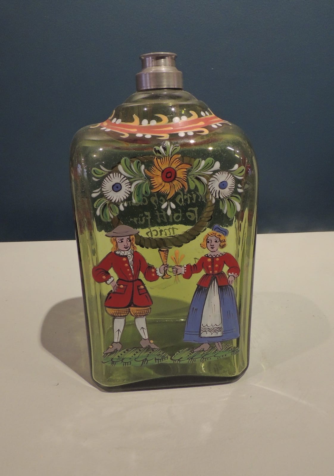 Green glass flat bottle decorated by a courting couple