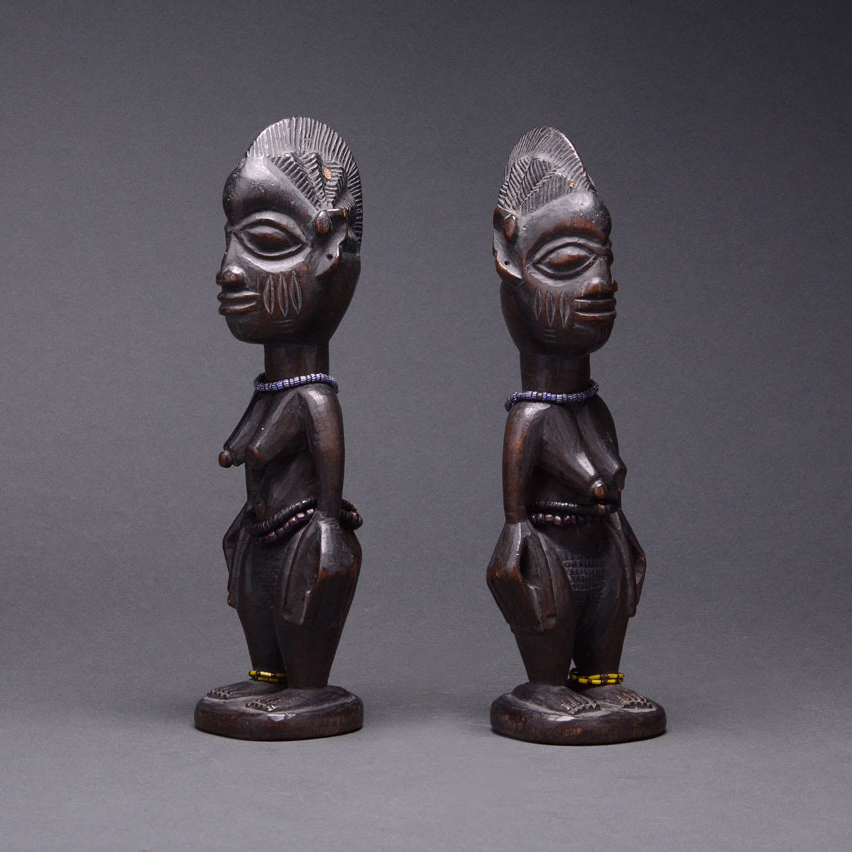 Pair of Yoruba Wooden Ibeji Doll with Cowrie Shell Cloak, 20th Century CE