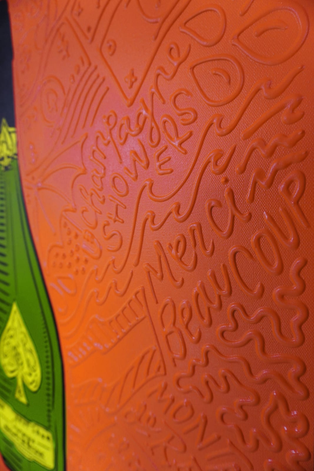 Detail photo of “La Botella”, painting by Cayla Birk artist from South Florida. Available at Carousel Fine Art Atlanta. The artist’s technique blends traditional acrylic paints with unique materials, creating a distinct mixed media style. Birk's work is marked by intricate designs and recognizable gestures, combining contemporary culture, history, music, and literature. Her art challenges conventional thinking, offering new and unexpected experiences. Colors of this work : Orange, Green, Yellow, Beige, Black