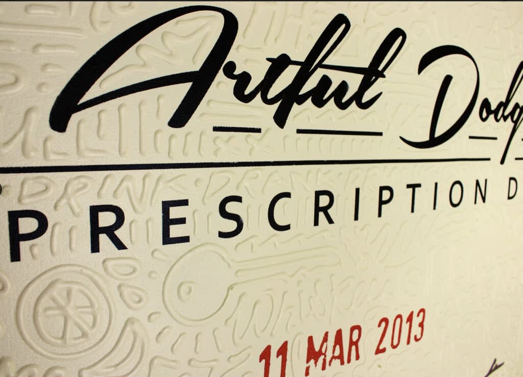 Detail photo of “Whiskey Neat”, painting by Cayla Birk artist from South Florida. Available at Carousel Fine Art Atlanta. The artist’s technique blends acrylic, spray paint and silicone on canvas, creating a distinct mixed media style. Birk's work is marked by intricate designs and recognizable gestures, combining contemporary culture, history, music, and literature. Her art challenges conventional thinking, offering new and unexpected experiences. Colors of this work : Beige, Red, Black