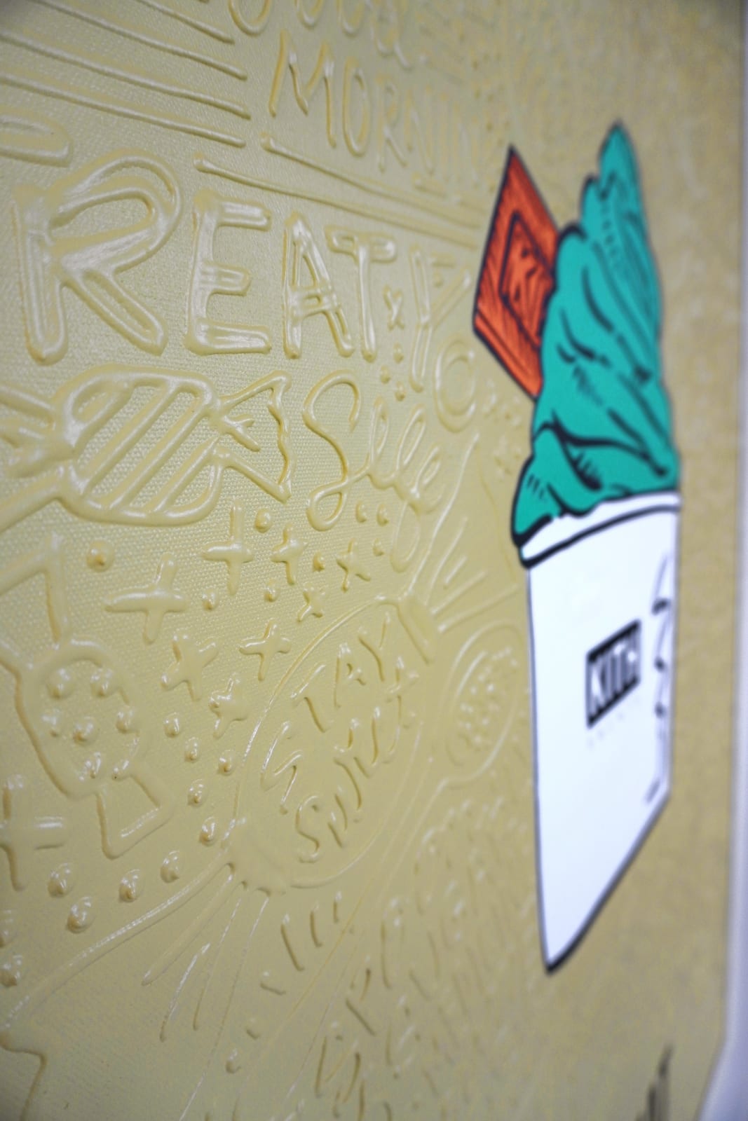 Detail photo of “El Treat”, painting by Cayla Birk artist from South Florida. Available at Carousel Fine Art Chicago. The artist’s technique blends traditional acrylic paints with unique materials, creating a distinct mixed media style. Birk's work is marked by intricate designs and recognizable gestures, combining contemporary culture, history, music, and literature. Her art challenges conventional thinking, offering new and unexpected experiences. Colors of this work : Teal, Orange, Beige, White, Black