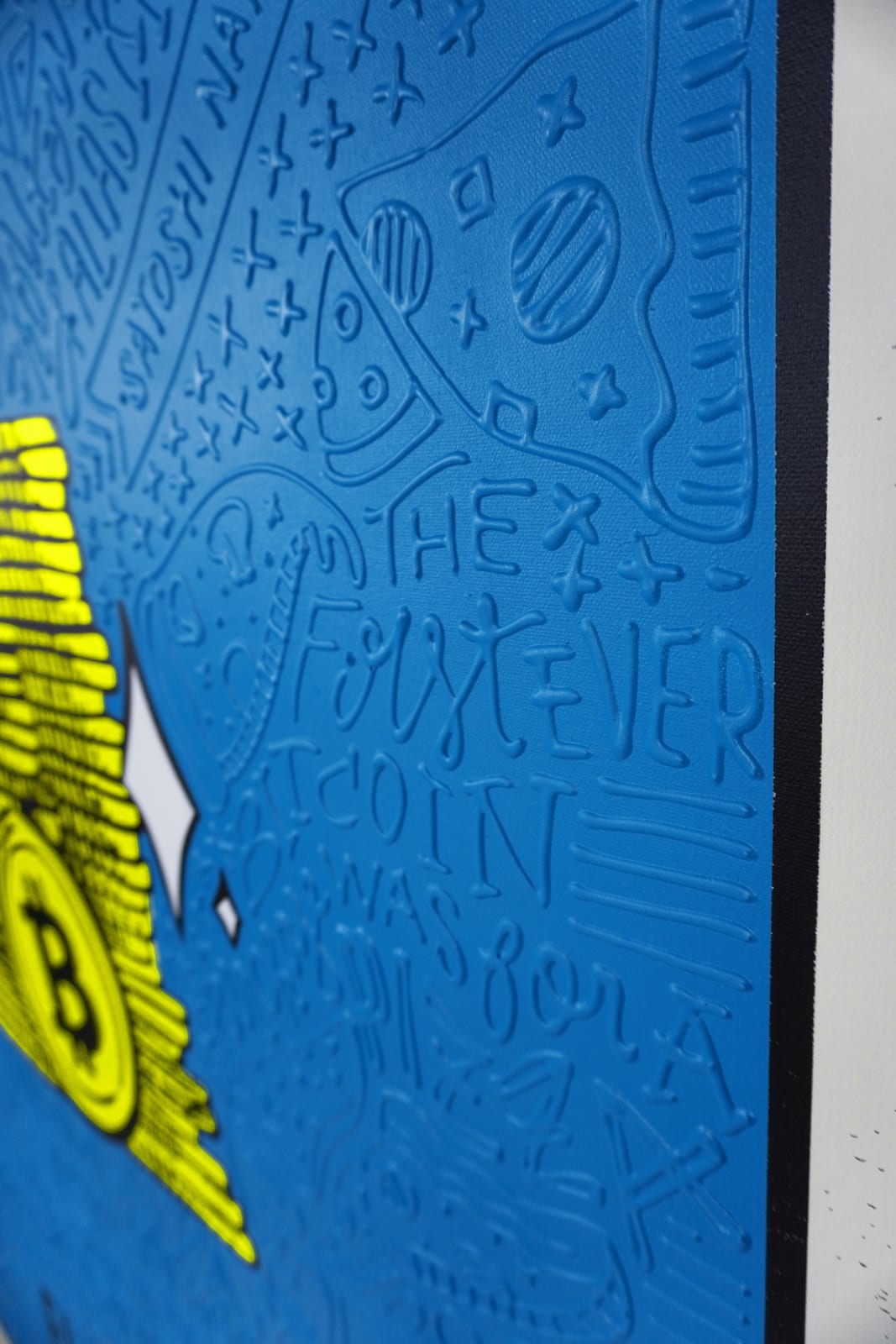 Detail photo of “El Bitcoin”, painting by Cayla Birk artist from South Florida. Available at Carousel Fine Art Atlanta. The artist’s technique blends traditional acrylic paints with unique materials, creating a distinct mixed media style. Birk's work is marked by intricate designs and recognizable gestures, combining contemporary culture, history, music, and literature. Her art challenges conventional thinking, offering new and unexpected experiences. Colors of this work : Blue, Yellow, Grey, White, Black