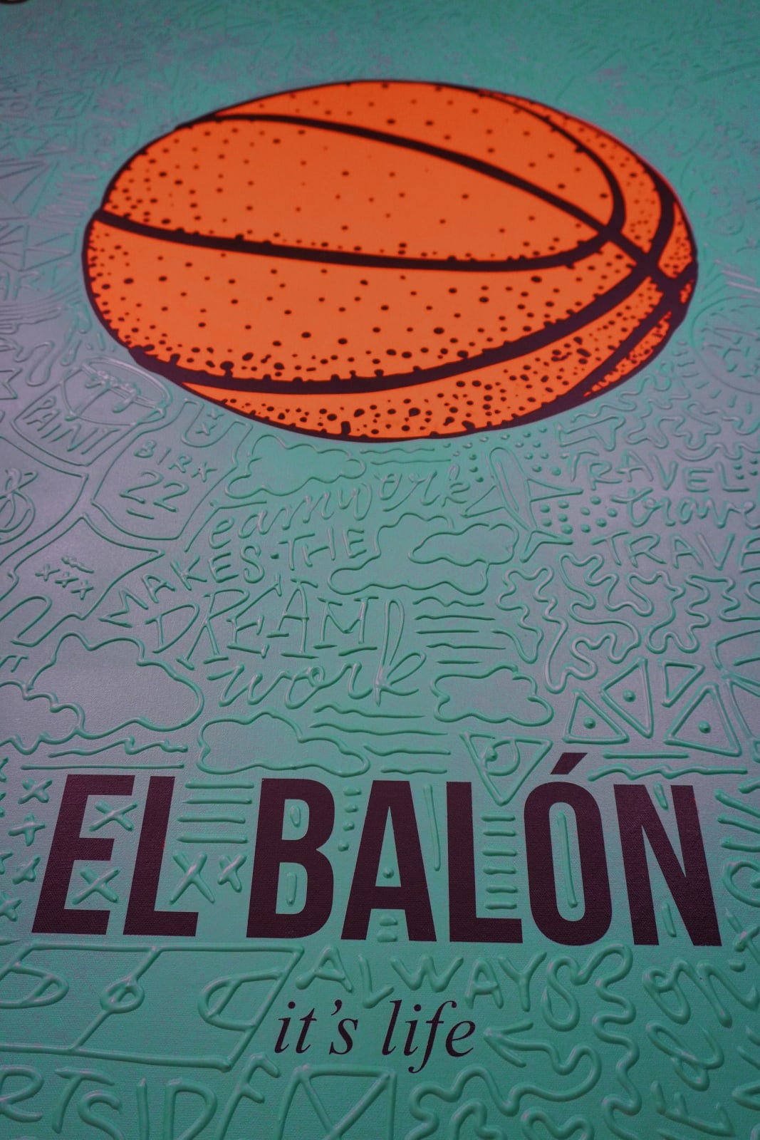 Detail photo of “El Balón”, painting by Cayla Birk artist from South Florida. Available at Carousel Fine Art Chicago. The artist’s technique blends traditional acrylic paints with unique materials, creating a distinct mixed media style. Birk's work is marked by intricate designs and recognizable gestures, combining contemporary culture, history, music, and literature. Her art challenges conventional thinking, offering new and unexpected experiences. Colors of this work : Teal, Orange, Beige, Black