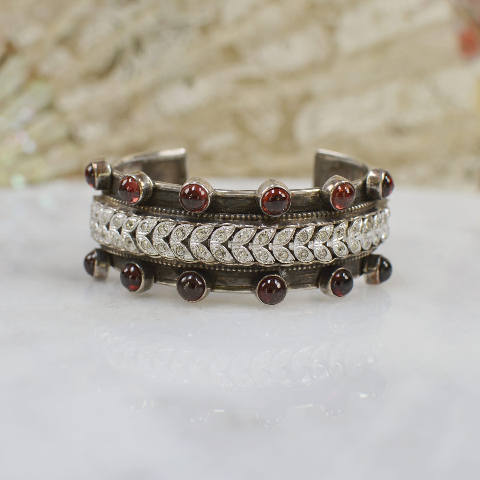 Jill Garber, WISDOM CUFF WITH EARLY TWENTIETH CENTURY FRENCH PASTE VINE EDGED WITH NATURAL GARNET CABOCHONS UPON 7/8” FLORAL BAND