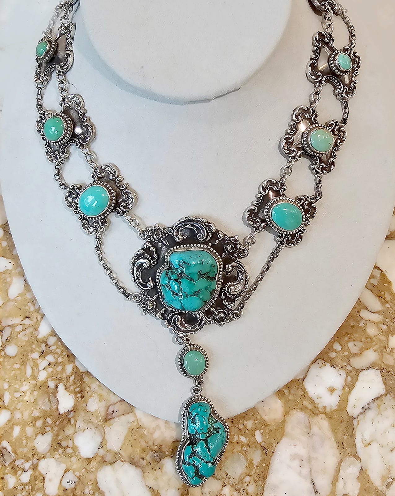 Jill Garber, A collection of cohesively coordinated Natural American turquoise nougats have been wonderfully set against a collection of substantial figural English links in this English inspired necklace with a Native American twist